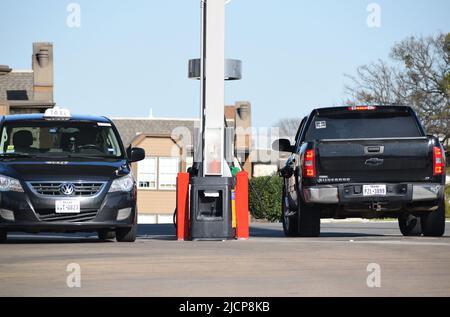 Ein schwarzer Chevrolet Silverado mit einem „Come and take it“-Stick in seinem hinteren Fenster, der an einer Gaspumpe geparkt ist Stockfoto