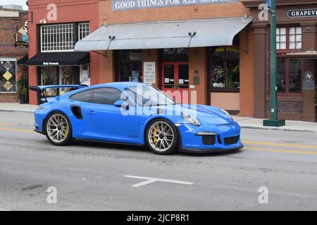 Ein hellblauer Porsche GT3RS, der die Main Street in Grapevine Texas entlang fährt Stockfoto