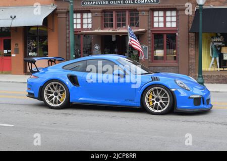 Ein hellblauer Porsche GT3RS, der die Main Street in Grapevine Texas entlang fährt Stockfoto