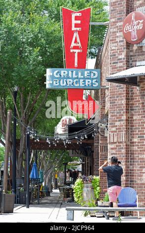 Ein „Eat here“-Schild mit dem Schild „Grilled Burgers Neon“ im Restaurant Twisted Root Burger Co. In Roanoke, Texas Stockfoto