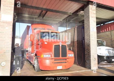 Halbtrucks, die am frühen Morgen bei einer LKW-Waschanlage in Irving, Texas, gewaschen werden Stockfoto