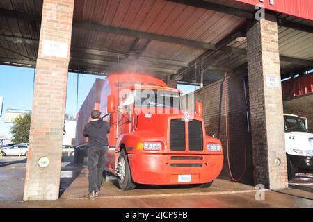 Halbtrucks, die am frühen Morgen bei einer LKW-Waschanlage in Irving, Texas, gewaschen werden Stockfoto