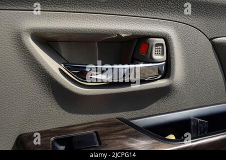 Blick auf die Tür des Autogriffs offen SCHLIESSEN Schlosssystem aus dem Innenraum des Maruti suzuki Ertiga Autos. Metalltür des Vordersitzes für Kindersicherung Stockfoto
