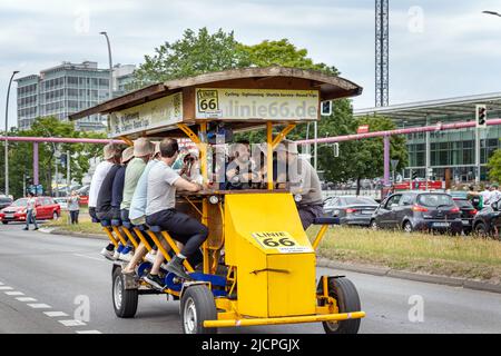 Eine Gruppe von Männern, die in Berlin ein Big Bike oder ein Bier Bike fahren. Stockfoto