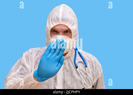 Mann Arzt Sanitäter in einem Schutzanzug Uniform mit Brille und Gesichtsmaske auf einem Studio blauen Hintergrund. Sanitäter in weißer antiviraler Schutzkleidung Stockfoto