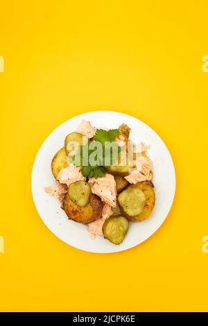 Frisch gebackener Lachs mit gebratener Kartoffel und Gurke auf dem Teller Stockfoto