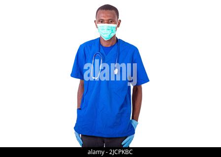Junger Arzt in blauer Uniform mit medizinischer Maske mit Stethoskop. Stockfoto