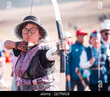 Isyk-Kul, Kirgisistan - 29. September 2018: Frau mit Pfeil im Bogen, die sich auf das Schlagen eines Ziels konzentrierte Stockfoto