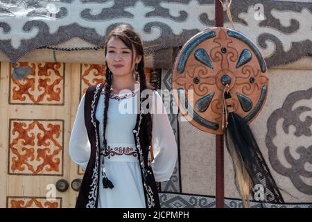 Isyk-Kul, Kirgisistan - 29. September 2018: Kirgisische Frau in Nationaltracht, die während der World Nomad Games in der Nähe von Jurten steht Stockfoto