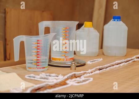 Werkzeuge zur Herstellung von Epoxidharz. Prozess der Herstellung eines Kunstharz und Holztisch. Stockfoto