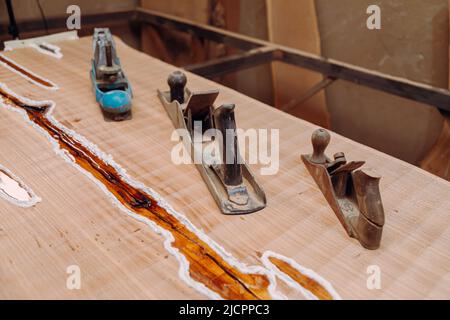 Alte Jointer-Ebenen liegen auf Holztisch. Holzbearbeitungswerkzeuge auf Holztisch. Schreinerei Stockfoto