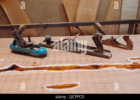 Alte Jointer-Ebenen liegen auf Holztisch. Holzbearbeitungswerkzeuge auf Holztisch. Schreinerei Stockfoto