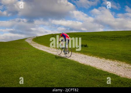Oldtimer-Radfahrer, die auf der Schotterpiste zum Hoad-Denkmal beim Veloretro-Radrennen in Ulverston, Cumbria, Großbritannien, fahren. Stockfoto