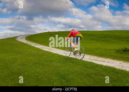 Oldtimer-Radfahrer, die auf der Schotterpiste zum Hoad-Denkmal beim Veloretro-Radrennen in Ulverston, Cumbria, Großbritannien, fahren. Stockfoto