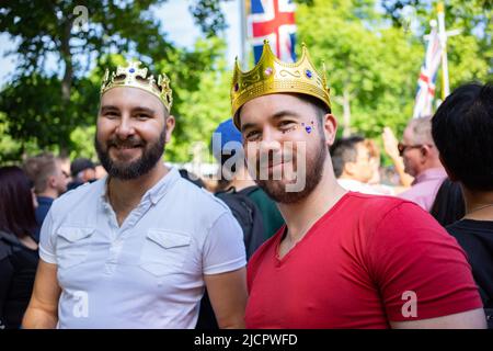 Zwei lächelnde Männer tragen goldene Kronen in der Mall in London, England, Großbritannien Stockfoto