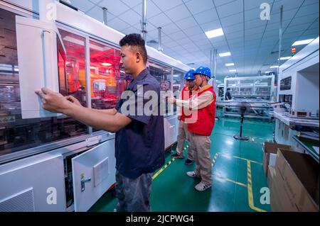 YANGZHONG, CHINA - 15. JUNI 2022 - Ein Servicemitglied verwendet eine Infrarot-Temperaturpistole, um die Temperatur der Produktionsanlagen in der sol zu messen Stockfoto