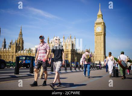 Die Menschen genießen das sonnige Wetter auf der Westminster Bridge, neben den Houses of Parliament, London. Bilddatum: Mittwoch, 15. Juni 2022. Stockfoto