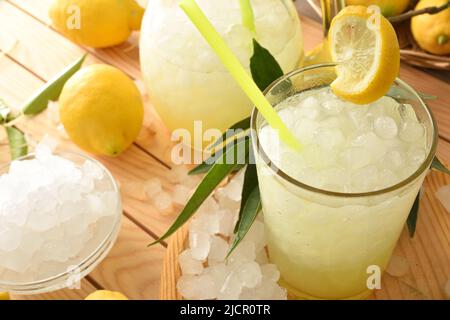 Detail der Limonade mit Eis in einem Glas auf einem Holztisch mit Früchten und zerdrücktem Eis. Erhöhte Ansicht. Horizontale Zusammensetzung. Stockfoto