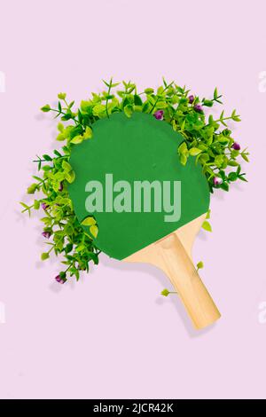 Kreative Grafik Collage von Tischtennisschläger mit grünem Laub Freizeit entspannen Konzept isoliert lila Farbe Hintergrund Stockfoto