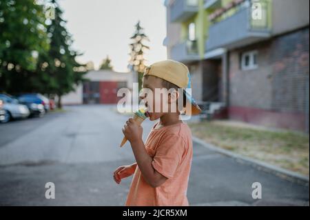 Kleiner niedlicher Junge mit Eis im Freien im Sommer Stockfoto