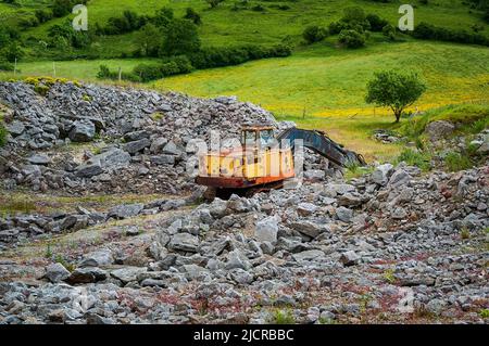 Stapel von Kalksteinblöcken und ein rostiger alter 360-Grad-Bagger in einem verlassenen Steinbruch auf einem alten Minengelände in der Nähe von Bradwell, Peak District. Stockfoto