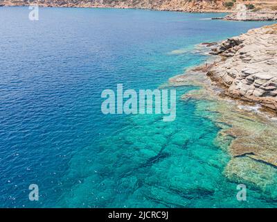 Azure Wasser Textur, transparente Meeresoberfläche mit einem felsigen Boden. Luftaufnahme, natürlicher blauer Hintergrund Stockfoto