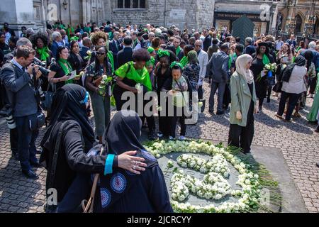 London, Großbritannien. 14.. Juni 2022. Vor der Westminster Abbey stellen Menschen weiße Rosen in Erinnerung an die 72 Menschen, die vor fünf Jahren beim Feuer in Grenfell ums Leben kamen. Fünf Jahre nach der Katastrophe begannen Feuerüberlebende und Hinterbliebene im Grenfell Tower einen Gedenktag und forderten, dass die Behörden endlich Gerechtigkeit üben. Kredit: SOPA Images Limited/Alamy Live Nachrichten Stockfoto