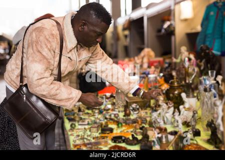 Afroamerikanischer Mann wählt Antiquitäten auf dem Flohmarkt Stockfoto