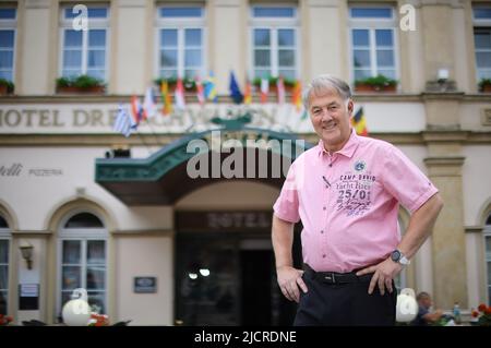 08. Juni 2022, Sachsen, Hohenstein-Ernstthal: Bernd Frank, Geschäftsführer des Hotels drei Schwanen, steht vor seinem Haus und freut sich auf die Gäste. Nach einer zweijährigen Pause wird das traditionelle MotoGP-Rennen wieder mit Zuschauern ausgetragen. 2020 war sie wegen Corona abgesagt worden, 2021 fand sie ohne Besucher statt. Auf ihrem Höhepunkt pilgerten rund 200.000 Besucher auf die Rennstrecke. Foto: Jan Woitas/dpa Stockfoto