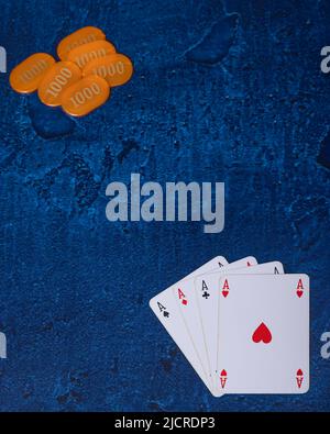 Pokerkarten und orangefarbene Chips auf hellblauem Hintergrund Stockfoto