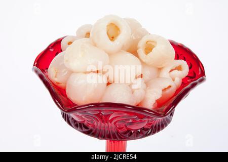 Litschi in roter Schale auf weißem Hintergrund Stockfoto