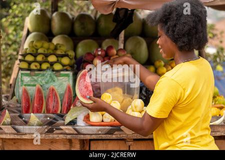 Porträt einer jungen afrikanischen Frau, die Früchte verkauft Stockfoto