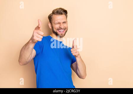 Foto von jungen fröhlichen Kerl gute Laune zeigen Finger entscheiden empfehlen isoliert über beige Farbe Hintergrund Stockfoto