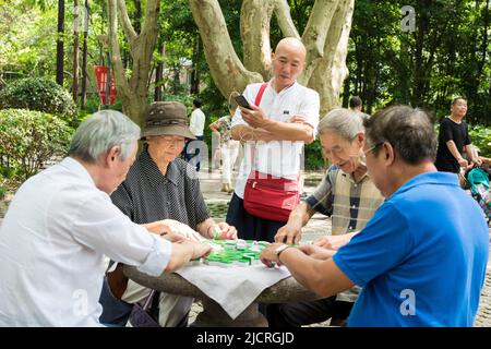 Die Chinesen spielen Mahjong im öffentlichen Park des People's Square in Shanghai. Stockfoto