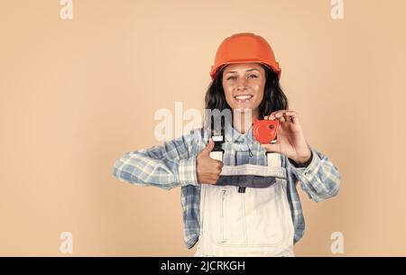 Entwickelt, um Preform. Techniker arbeiten mit Maßband Werkzeug. Sicherheitsuniform. Ausrüstung für die Reparatur. Mechaniker Mädchen in schützenden Hardhat Stockfoto