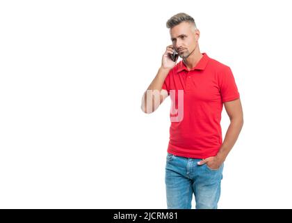 Grizzled Mann in rotem T-Shirt sprechen auf Smartphone isoliert auf weißem Hintergrund Stockfoto