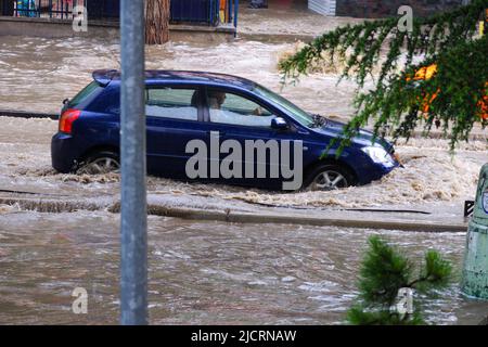 Auto bewegt sich auf überfluteter Straße Stockfoto