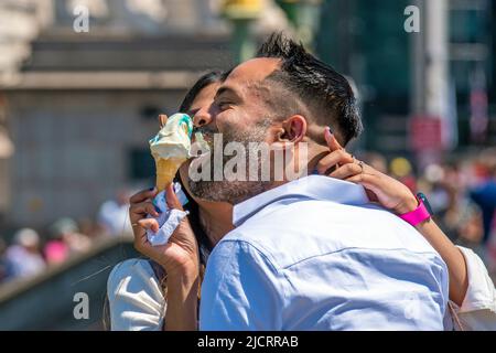 London, Großbritannien. 15.. Juni 2022. Ein Paar teilt sich auf der Westminster Bridge ein Eis und einen Kuss. Am sonnigen Mittwoch genießen die Menschen die Sonne am Südufer der Themse. Kredit: JOHNNY ARMSTEAD/Alamy Live Nachrichten Stockfoto