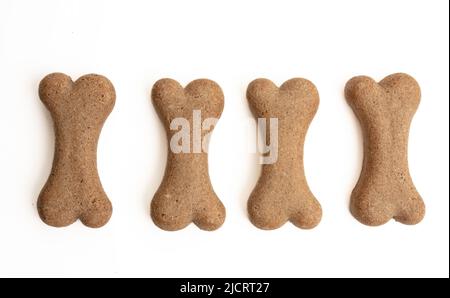 Hundefutter Biskuit Form Knochen isoliert auf weißem Hintergrund. Vier leere Snacks hintereinander, Platz zum Kopieren Stockfoto