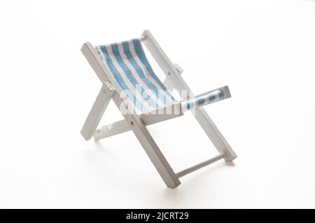 Strandstuhl, weiß blau gestreifter Liegestuhl isoliert auf weißem Hintergrund. Ruhe und Entspannung, Sommerurlaub Stockfoto