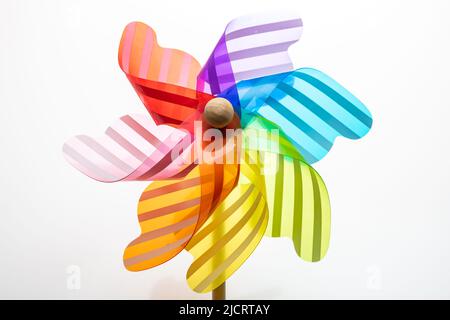 Pinwheel isoliert auf weißem Hintergrund. Regenbogen Farbe Windmühle Spielzeug auf einem Holzstab Stockfoto