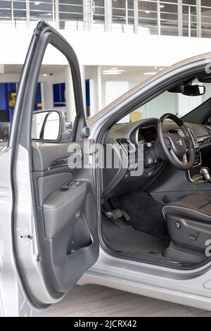 Russland, Izhevsk - 4. März 2022: Jeep Showroom. Innenraum des neuen modernen Grand Cherokee Autos im Händlerraum. Ansicht mit geöffneter Fahrertür. Stockfoto