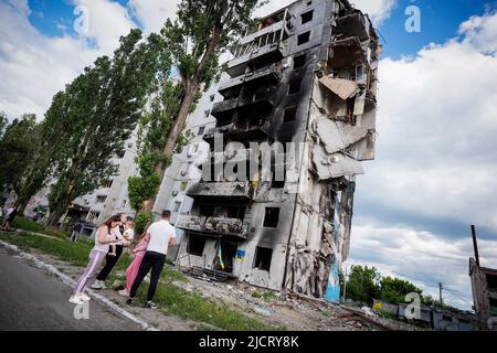 Borodjanka, Ukraine. 15.. Juni 2022. Die Bewohner stehen vor zerstörten Wohngebäuden in Borodyanka. Russland hatte die Ukraine Ende Februar angegriffen, ohne den Krieg zu erklären. Besonders nach dem Abzug der Russen aus den nordwestlich von Kiew gelegenen Vororten Butscha, Irpin, Hostomel und Borodjanka hatten Bilder scheinbar hingerufene Menschen weltweit für Entsetzen gesorgt. Quelle: Kay Nietfeld/dpa/Alamy Live News Stockfoto