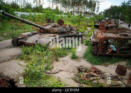 Irpin, Ukraine. 15.. Juni 2022. Zerstörte Panzer stehen am Straßenrand bei Irpin. Russland hatte die Ukraine Ende Februar angegriffen, ohne den Krieg zu erklären. Besonders nach dem Abzug der Russen aus den nordwestlich von Kiew gelegenen Vororten Butscha, Irpin, Hostomel und Borodjanka hatten Bilder scheinbar hingerufene Menschen weltweit für Entsetzen gesorgt. Quelle: Kay Nietfeld/dpa/Alamy Live News Stockfoto