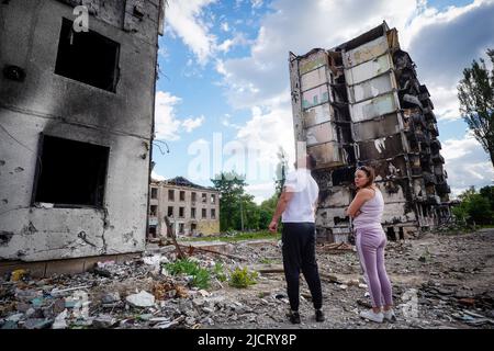 Borodjanka, Ukraine. 15.. Juni 2022. Die Bewohner stehen vor zerstörten Wohngebäuden in Borodyanka. Russland hatte die Ukraine Ende Februar angegriffen, ohne den Krieg zu erklären. Besonders nach dem Abzug der Russen aus den nordwestlich von Kiew gelegenen Vororten Butscha, Irpin, Hostomel und Borodjanka hatten Bilder scheinbar hingerufene Menschen weltweit für Entsetzen gesorgt. Quelle: Kay Nietfeld/dpa/Alamy Live News Stockfoto