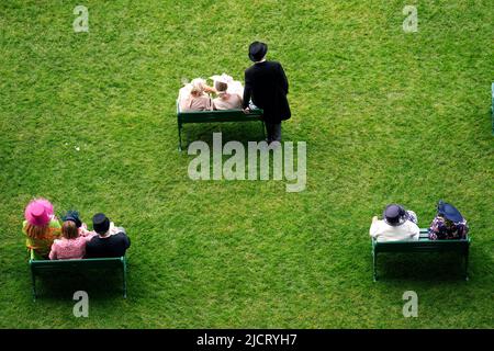 Rennfahrer sitzen auf Bänken, während sie die Tage beim Rennen am zweiten Tag von Royal Ascot auf der Pferderennbahn Ascot beobachten. Bilddatum: Mittwoch, 15. Juni 2022. Stockfoto