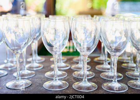 Eine Gruppe von vielen sauberen transparenten leeren Weingläsern, die in einer Reihe angeordnet sind. Stockfoto