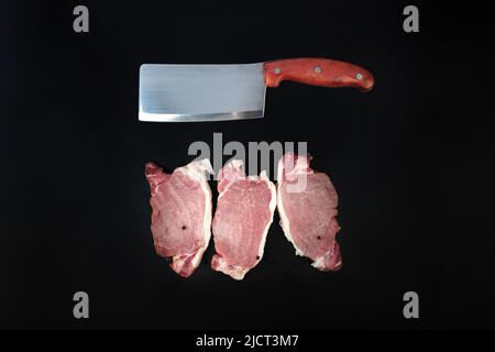 Rohes Kalbsfilet, verschiedene Steaks aus rohem Rindfleisch zum Grillen mit Fleischmesser auf dunklem Hintergrund Stockfoto