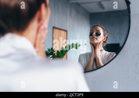 Die junge Frau kümmert sich um ihre Gesichtshaut Stockfoto