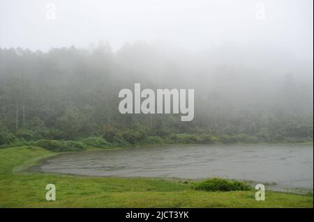 Mountain Province, Philippinen: Ätherischer Nebel umhüllt den Danum-See (Kankana-ey für Wasser) an einem regnerischen Nachmittag in Sagada. Horizontaler Kopierbereich. Stockfoto